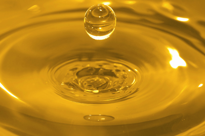 Close-up van een oliedruppel die in olie valt.